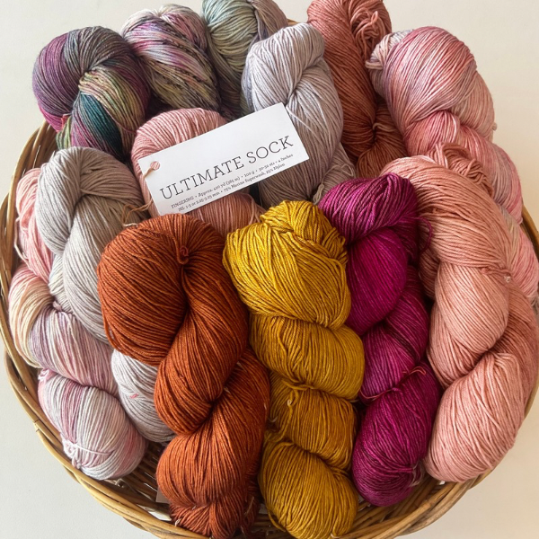 Basket of colorful yarn with a 'Ultimate Sock' label on a light background Malabrigo Ultimate Sock 4ply Yummy Yarn and co